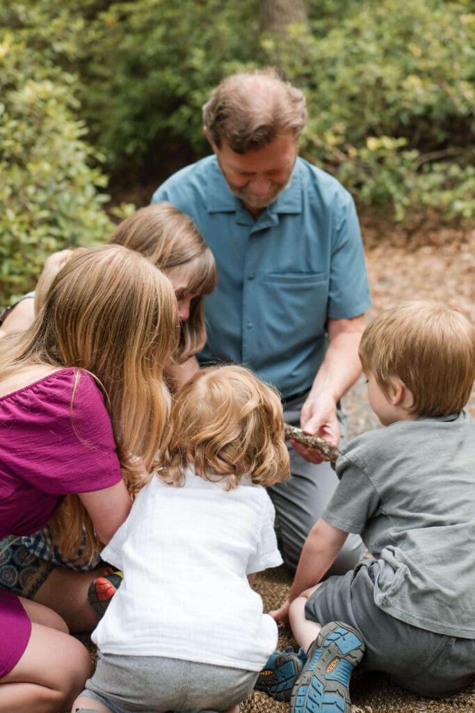 A grandfather shows his kids a stick at Whip Hill Park in Stoneham. 