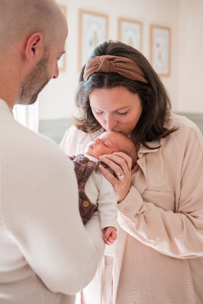 A Wakefield Photographer captures a mother kissing her newborn in this North Shore newborn session. 